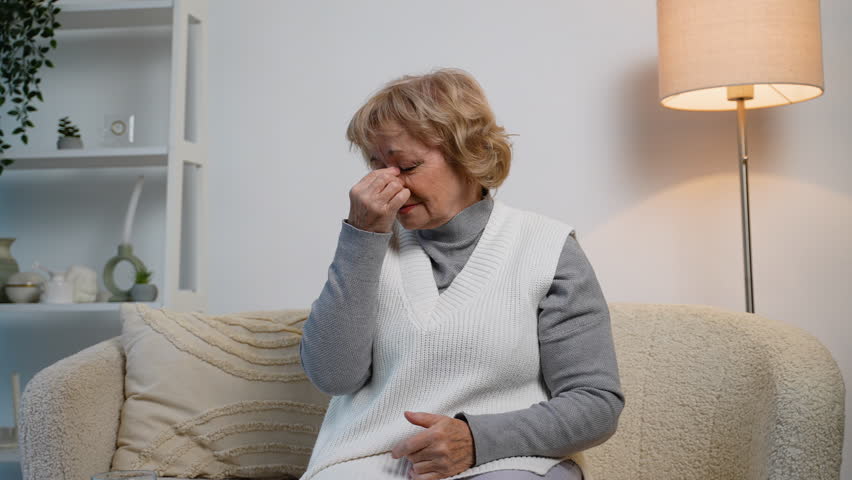 Elderly woman suffering from sinus pain or nasal congestion