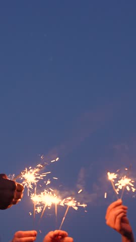 Sparkler party. Girls have fun in nature with sparklers. Bengali flicker. Fun party with bright sparklers in hands. People fun night . Group happy young girls play sparklers on background of night sky