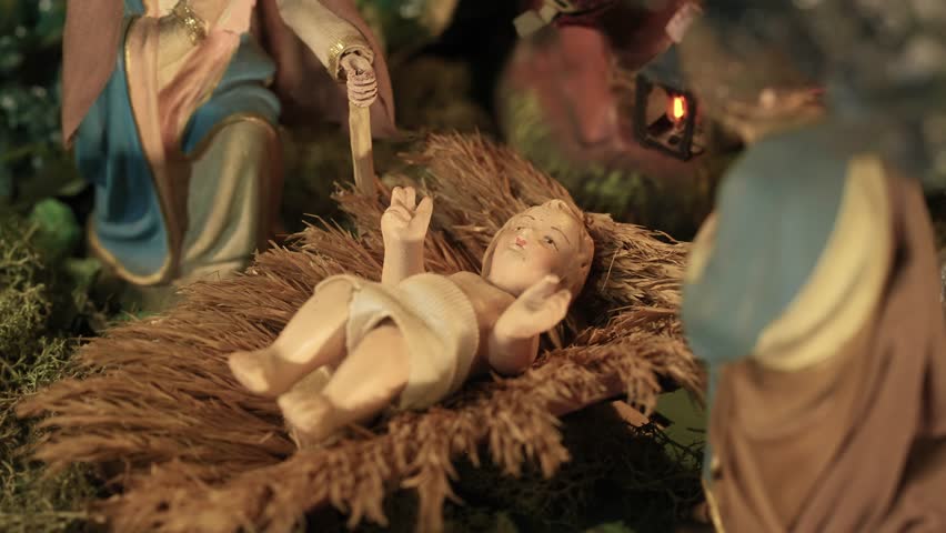 Close up of baby Jesus figurine lying in a manger in a moving nativity scene