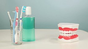 Smiling denture jaws chatter next to dental care products on clean background - Powered by Shutterstock - Get 15% off with code: PIKWIZARD15