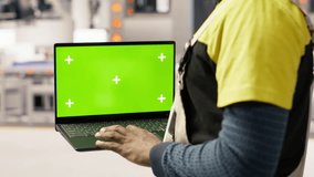 Factory engineer using green screen laptop to calibrate high tech machinery and analyze sensor data. Industrial plant employee uses chroma key notebook to troubleshoot assembly equipment, camera B - Powered by Shutterstock - Get 15% off with code: PIKWIZARD15