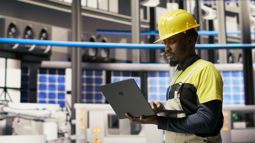 Technician in industrial plant overseeing solar energy installation process, troubleshooting errors. Renewable energy manufacturing facility employee calibrating automated robotic arms, camera B
