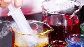 A scientist uses a syringe to mix vibrant liquids in a petri dish, showcasing a chemical reaction. - Powered by Shutterstock - Get 15% off with code: PIKWIZARD15