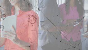 Woman holding tablet speaking with colleagues in tech office, network graphics floating over desk. Collaboration, innovation, digital, teamwork, communication, modern, technology - Powered by Shutterstock - Get 15% off with code: PIKWIZARD15