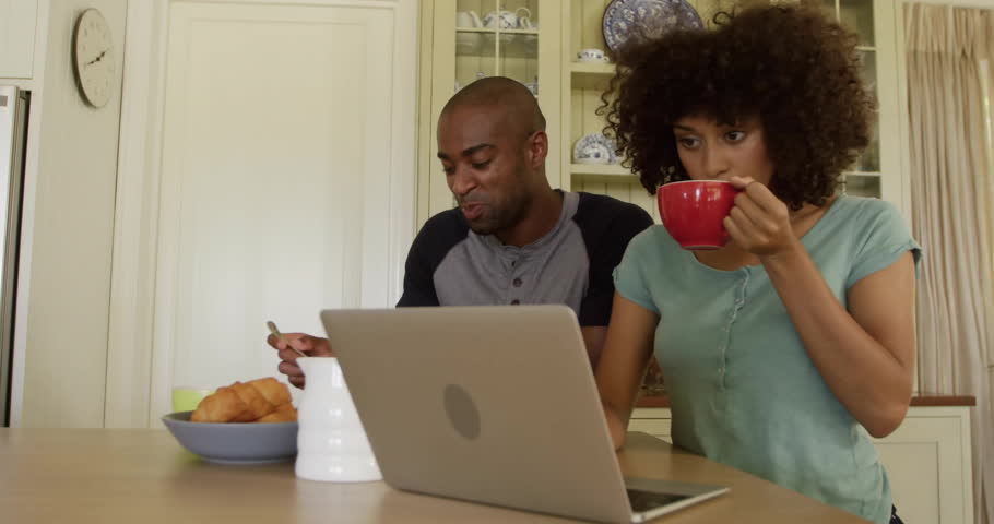 Business couple having breakfast at kitchen table, with floating data chart and laptop icons. Domestic, lifestyle, candid, cozy, modern, communication, teamwork