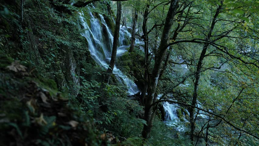 Plitvice National Park. Plitvice Lakes. Waterfall flowing into a clear blue lake. Waterfall creating a peaceful atmosphere.