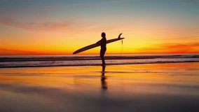 Wide Shot of Female Surfer Walking Towards Beach with Surfboard at Sunset in Costa da Caparica, Portugal - Powered by Shutterstock - Get 15% off with code: PIKWIZARD15