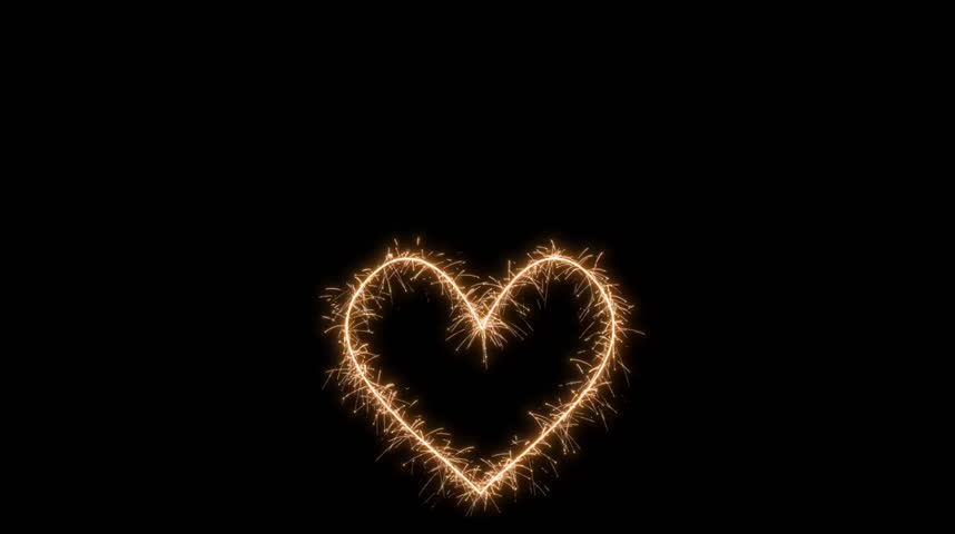 Glowing sparkler heart shape drawn in dark background

