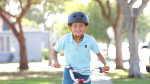 Boy rides bike into focus as he approaches camera. Shot on Canon 5d Mk2 with a frame rate of 30fps Stock Video