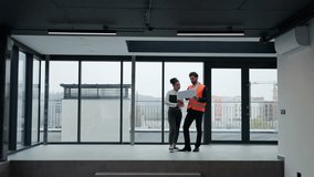 Professional investor and architect discuss blueprints in modern office space with large windows, expressing satisfaction and collaboration. - Powered by Shutterstock - Get 15% off with code: PIKWIZARD15