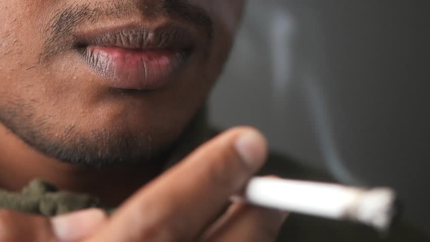 Close-up of man smoking cigarette in relaxed environment