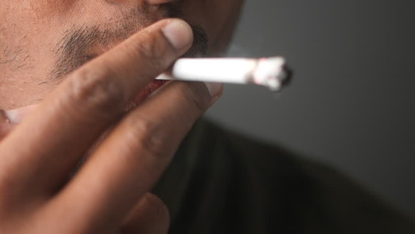 Close-up of man smoking cigarette in relaxed environment