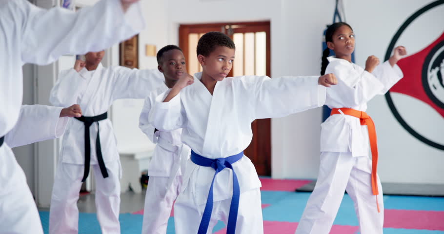 Children, karate and group with fighting or kick for self defense training, taekwondo or martial arts. Kids, learning and practice session with punching or technique for kata or lesson in aikido dojo