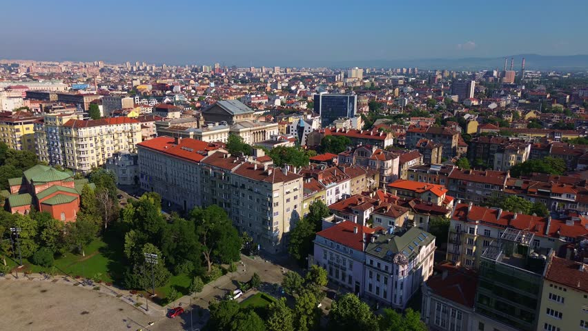 Flyover Sofia, Bulgaria. Drone flying over the city center, facing northeast, a sunny summer day. Drone shot of an East European capital city full of classical buildings mixed with modern architecture