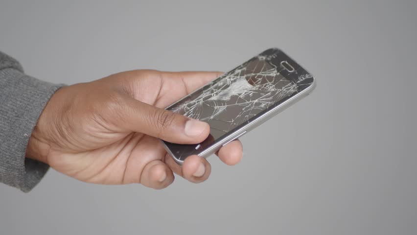 Close up of man hand holding broken smart phone.