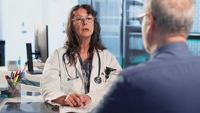 Skilled medical expert analyzing x ray scans for old patient on insurance, discussing with senior patient about protection and prevention for wellbeing. Professional advice. Camera A. - Powered by Shutterstock - Get 15% off with code: PIKWIZARD15