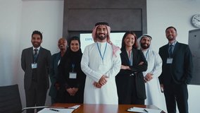 Multicultural businesspeople wearing suits and traditional clothing stand together in a modern office, embodying teamwork and cultural diversity. - Powered by Shutterstock - Get 15% off with code: PIKWIZARD15