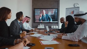 Multicultural business team with arab professionals engaging in video conference, discussing strategy with ceo on large screen in modern conference room. - Powered by Shutterstock - Get 15% off with code: PIKWIZARD15