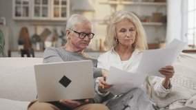Worried mature woman and husband discussing utility bills and mortgage papers. Aged people viewing legal documents, anxious elderly lady thinking about finance, decide money problems, medium shot - Powered by Shutterstock - Get 15% off with code: PIKWIZARD15