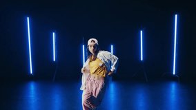 Talented dancer showcase her impressive moves on a dark stage illuminated by vertical blue neon lights, creating a vibrant and dynamic performance. - Powered by Shutterstock - Get 15% off with code: PIKWIZARD15