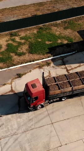 Apple harvest. A truck, full of wooden crates with freshly harvested apples, goes to storage warehouse. outdoors. aero. top view.