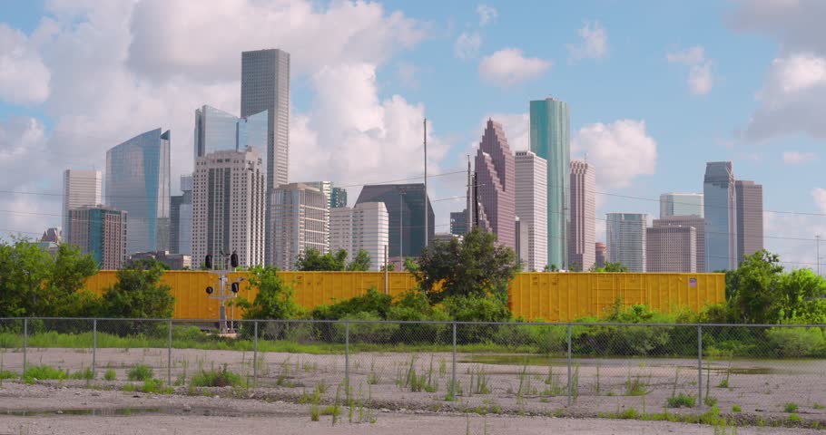 Establishing shot of downtown Houston, Texas on cloudy but sunny day as train passes by