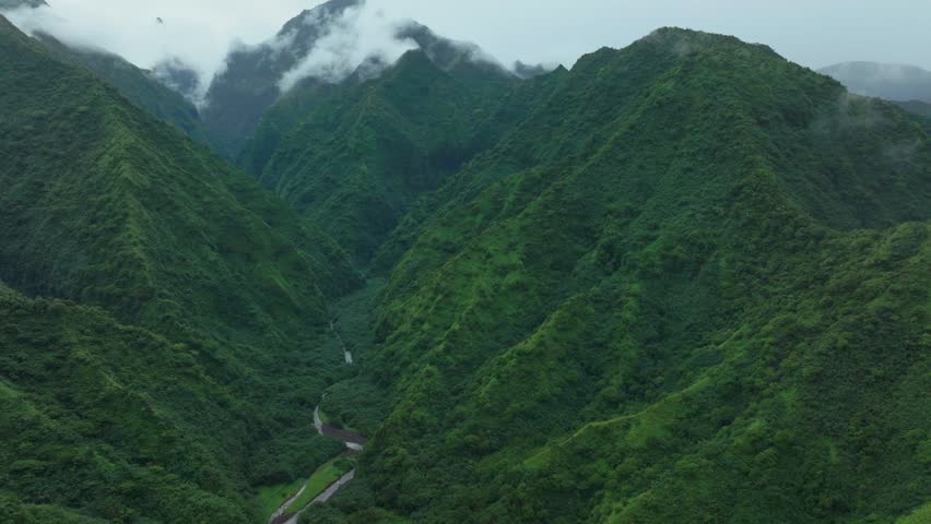 Tahiti French Polynesia Teahupoo aerial drone raining fog up the mountain peaks river morning grey gray season wet green Point Faremahora village town South Pacific Mount Tohivea island backwards pan
