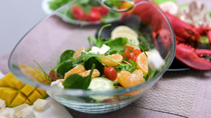Woman slices cut vegetables vegetable salad vegetarianism fish white cutting board, surrounded by other fresh fruits, ready to make a healthy fruit salad