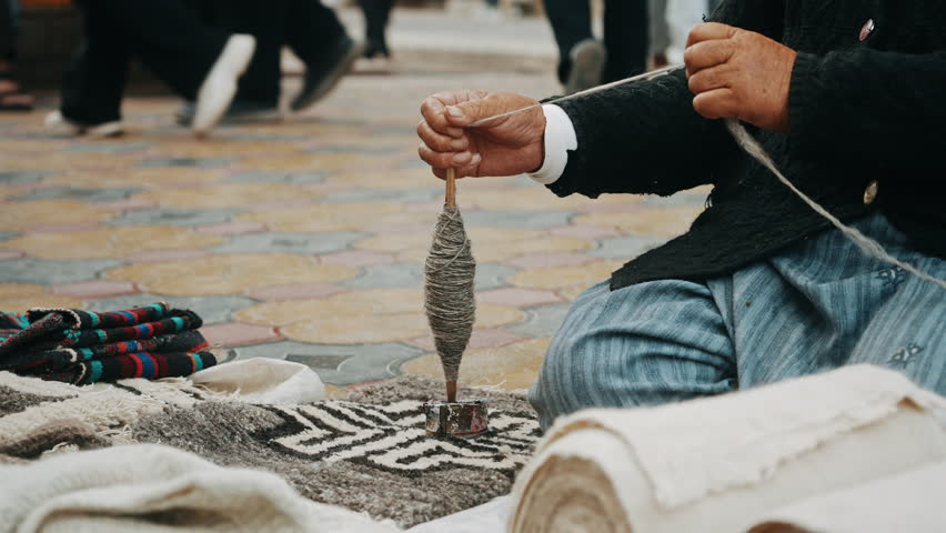 Elderly Woman Hand-Spinning Wool onto Bobbin 