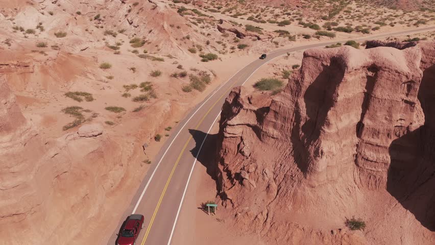 Cars passing on the road between the rock formations of the Quebrada de las Conchas, Salta, Argentina.
Drone shot forward.