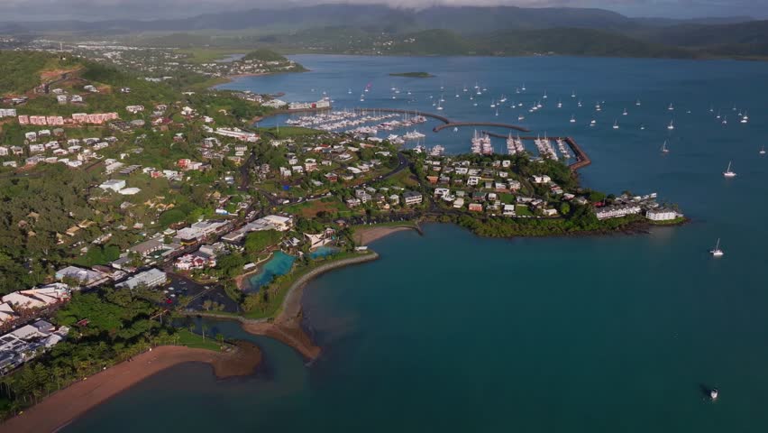 Airle Bay Beach aerial drone Coral Sea Marina Pioneer Bay Port Cannonvale heart of Great Barrier Reef Whitsundays islands Whitehaven sunrise morning mist clouds jetty sailboats backward reveal motion
