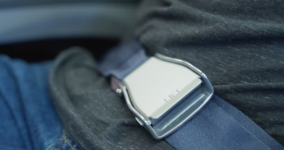 Open seatbelt on airplane. Unbuckle up your seatbelt on flight. Passengers seated inside the airplane with safety belts fastened, awaiting takeoff. Ensuring safety while traveling is crucial. landing