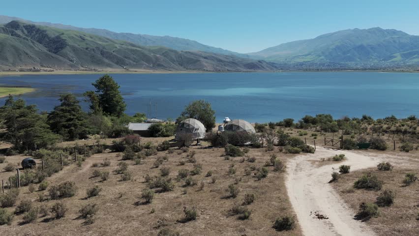 Beautiful landscape of the La Angostura dam with two Glamping domes on the shore. Tourism. Argentina, Tucuman, Tafí del Valle.