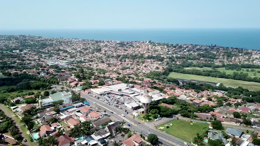 Aerial footage of a drone flying over residential houses overlooking a busy highway with moving traffic in a suburb of yellow wood park Durban 