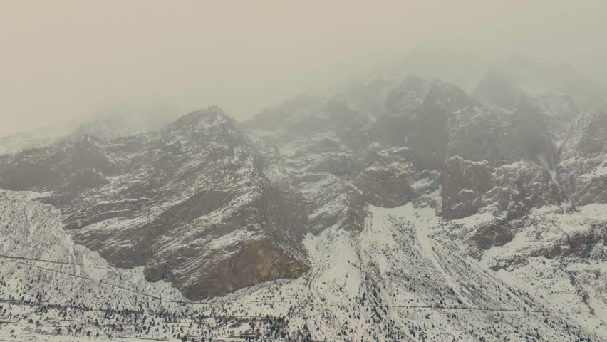 Drone Panning shot of mountain covered with snow in Northern Pakistan Naltar Valley Gilgit winter 