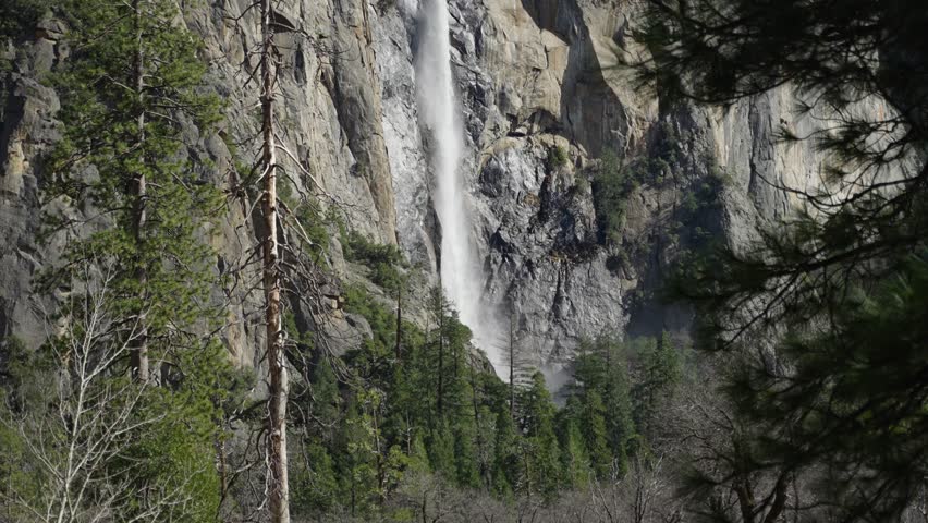 Panning up shot of a water fall on the cliffs of Yosemite National Park