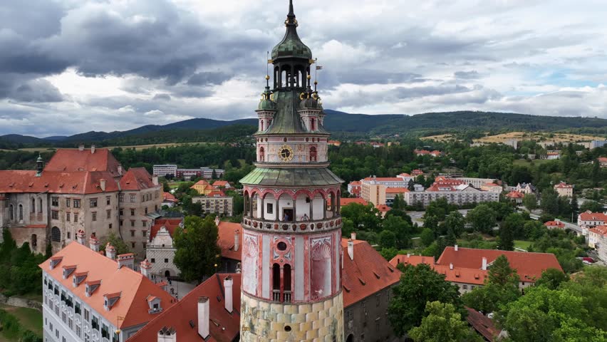 Český Krumlov, South Bohemia, Czechia, July 2023. Drone closeup parallax orbit around medieval clock and bell tower with detailed brickwork and tiling.