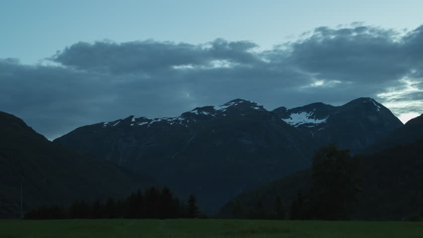 Timelapse of fast-moving clouds over mountains during the blue hour in Western Norway.