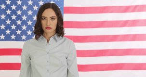 Determined woman asks to Stop Abortions with placard and hand gesture by USA flag. Right wing activist takes part in pro-life demonstration in America - Powered by Shutterstock - Get 15% off with code: PIKWIZARD15