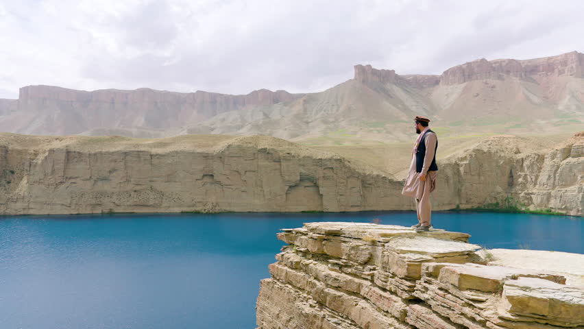 Arabian Man On Top Of Sandstone Cliffs In Band-e Amir National Park, Central Bamyan Province Of Afghanistan. Aerial Drone Shot