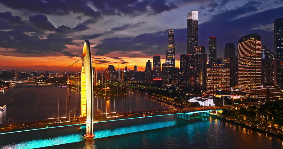 Aerial shot of modern city skyline and illuminated skyscrapers with bridge at night in Guangzhou, China.