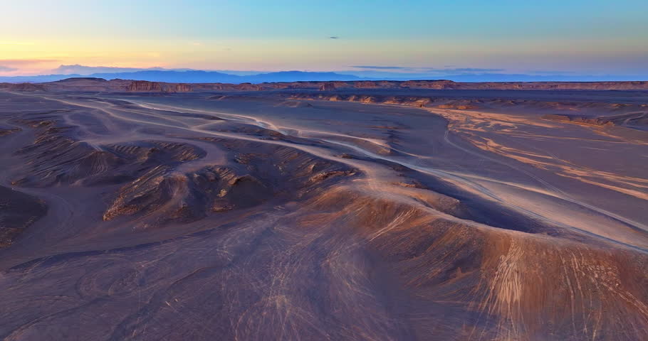 Aerial shot of the spectacular and desolate yardang landform desert landscape at sunset in Xinjiang, China.