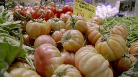 a vibrant market scene showcasing fresh heirloom tomatoes, green beans, and leafy vegetables. The colorful display highlights the variety and abundance of fresh, organic produce available.  - Powered by Shutterstock - Get 15% off with code: PIKWIZARD15