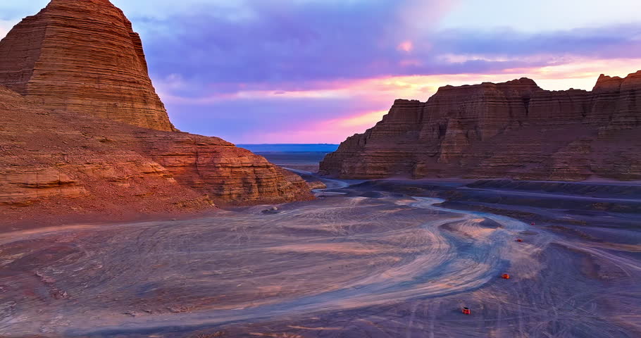 Desert road and Yardang landform mountain scenery at sunset. Famous Dahaidao no man's land natural landscape in Xinjiang, China.