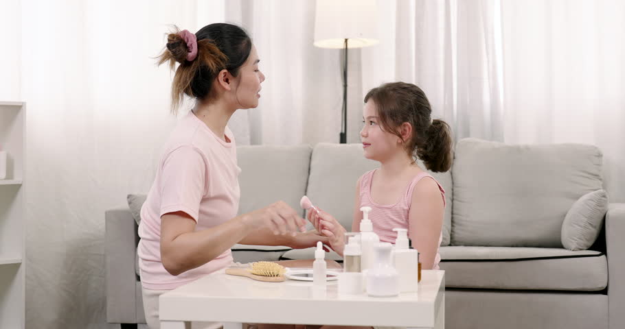 Little girl applying blush on mother