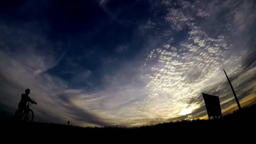 silhouette of a man with a bicycle at sunset