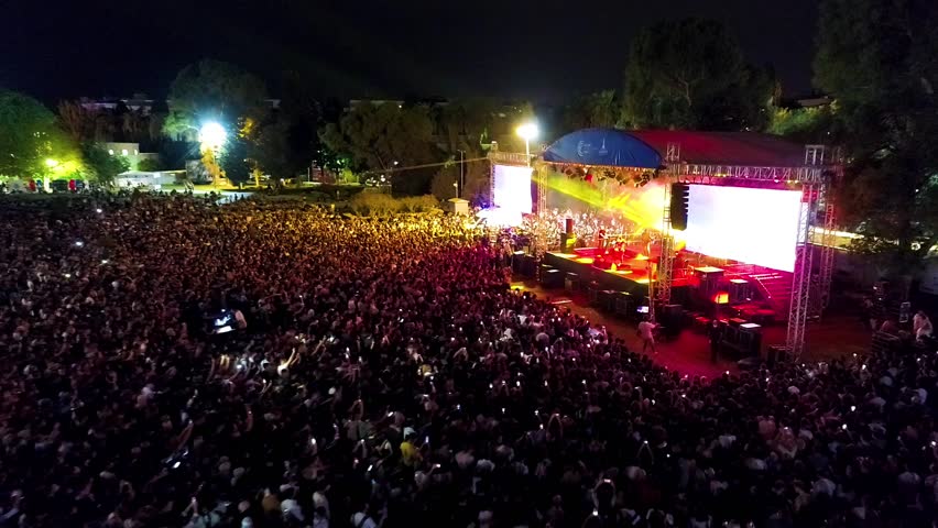Concert stage and people having fun - Crowd view of people having fun at a concert, stage and spotlights