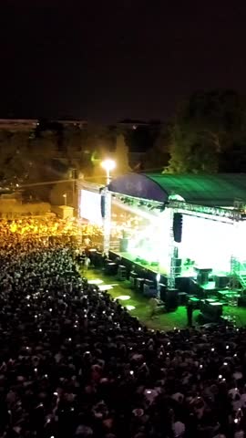 Vertical video at the concert - High quality aerial view of people having fun at the concert, concert stage and stage lights, lasers taken by drone