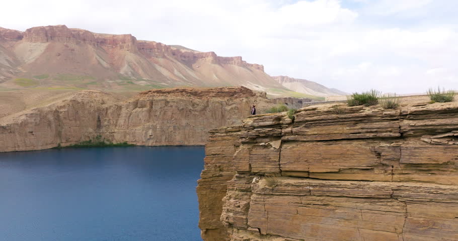 A Man On Top Of Sheer Cliffs Over Lakes In Band-e Amir National Park In Afghanistan. Aerial Drone Shot