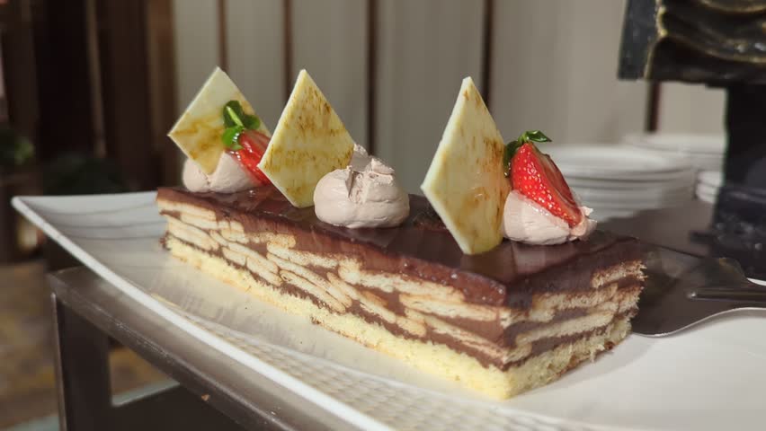 Elegant Slice of Opera Cake with Chocolate Glaze and Strawberry Garnish
